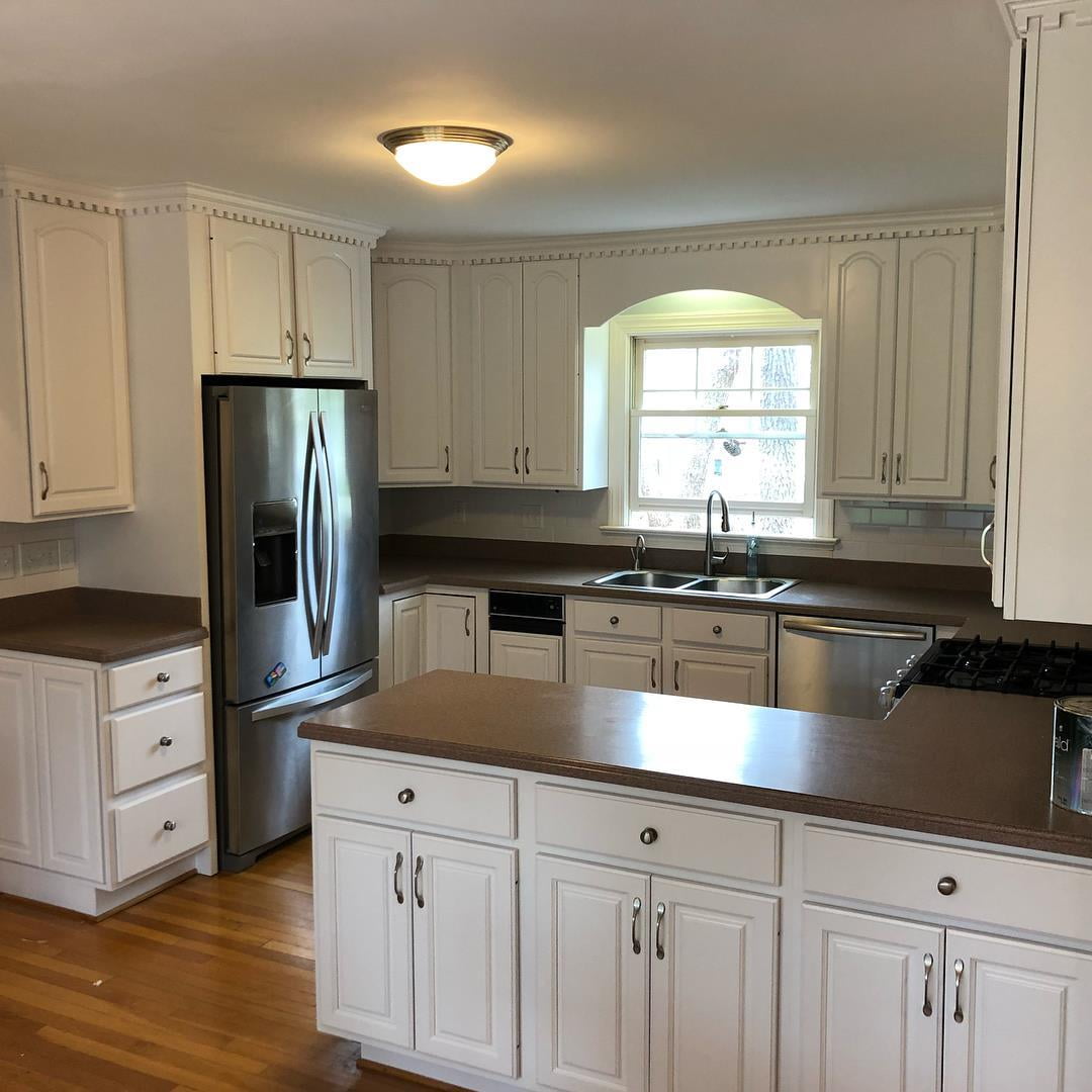 White refinished cabinets with dark countertop.