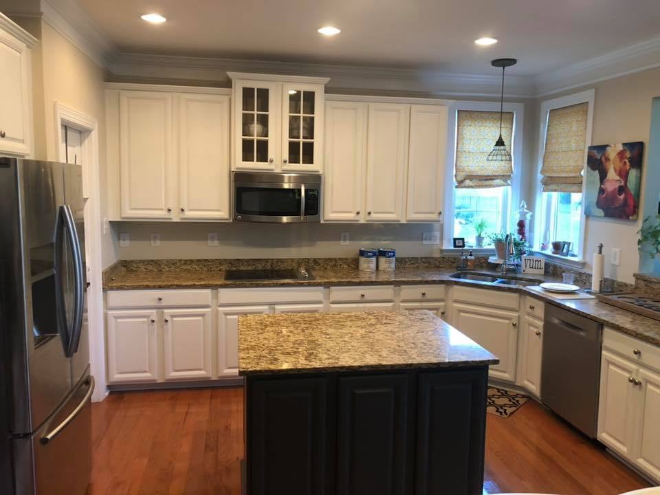 Cream colored top cabinets with granite countertops and white bottom cabinets.