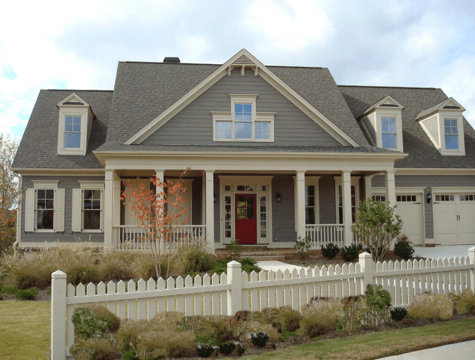 Large home being painted dark green.