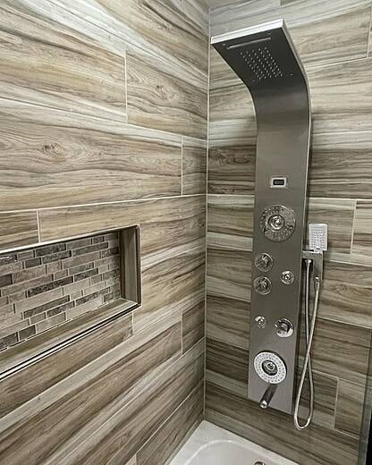 Grey tile and stainless steal shower hardware.